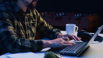 Entrepreneur working from home, using laptop and writing notes on paper. Remote worker in personal apartment office answering emails and transcribing important info on notepad video