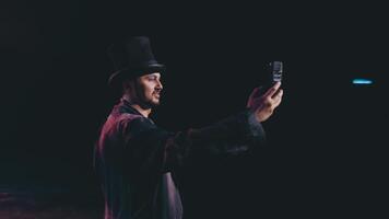 un teatro artista fotografias su imagen mientras en pie en escenario. selfies en escenario. video