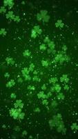 Vertical video - lucky shamrocks, shiny stars and glowing glittering particles on a dark green background. This Saint Patrick's Day celebration party background animation is full HD and looping.