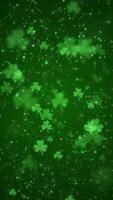 Vertical video - lucky shamrocks, shiny stars and glowing glittering particles on a dark green background. This Saint Patrick's Day celebration party background animation is full HD and looping.