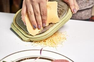 a person grating cheese on a plate photo