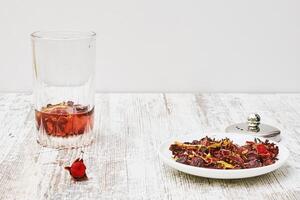 a bowl of dried flowers and a glass of water photo