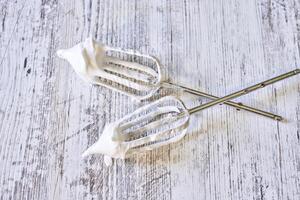 two white whisk sticks with whipped cream on them photo