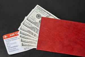 a red wallet with money and an air ticket photo