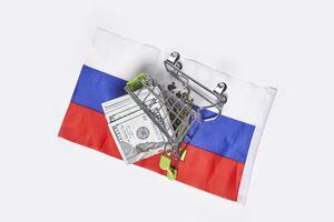 flag and shopping cart with money on white background photo