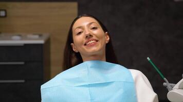 contento caucásico mujer sonriente a cámara, demostración blanco sonrisa de después dientes blanqueo procedimiento video