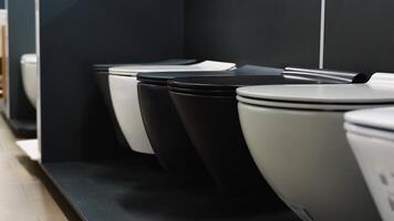 Ceramic toilet bowls of different types and color in a shop video