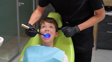 dentista ortodoncista operando con azul blanqueo lámpara, curación dientes, dental cuidado concepto video