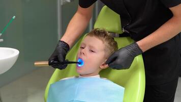 dentiste orthodontiste en fonctionnement avec bleu blanchiment uv lampe, guérir dents, dentaire se soucier concept video