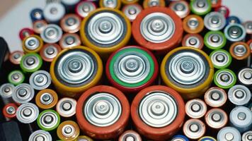 Different battery types rotate in a circle. Old used batteries video