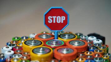 Stop pollution by batteries. Old used batteries type AA, AAA, D and stop sign rotate in a circle video