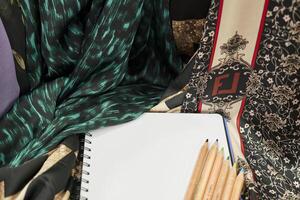 a notebook and pencils on a table photo