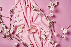 a pink fabric with flowers and a bottle of perfume photo