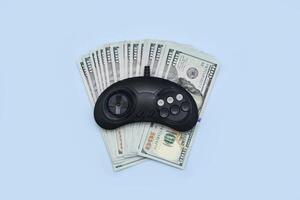 a video game controller and money on a blue background photo
