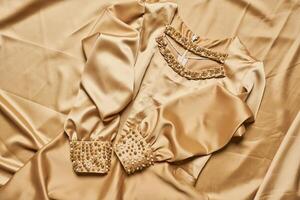 golden outfit on a silk satin photo