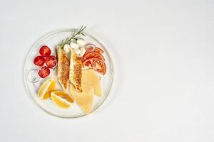 a plate of food with cheese, tomatoes, and lemon slices photo