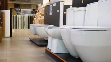 Ceramic toilet bowls of different types and color in a shop video