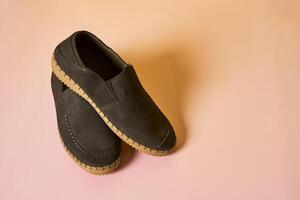 a pair of brown shoes on a pink background photo