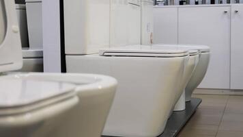 Showcase with toilets. Sale in the plumbing store of toilet bowls of different models video