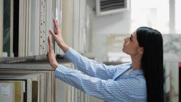 Woman browsing tile samples in home improvement store video