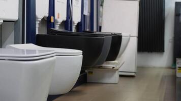 Ceramic toilet bowls of different types and color in a shop video