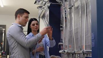 Young couple choosing shower tap in a plumbing store video