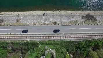 carro indo em uma estrada perto a rio, aéreo visualizar. imagens de vídeo. aéreo Visão às pequeno floresta lago e linha do rodovia passagem aproximar. carro indo em uma estrada perto a rio, aéreo visualizar. imagens de vídeo. aéreo Visão video