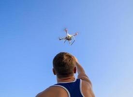 man takes to board a drone in his hand. Planting a drone. The flight of the Copter. photo