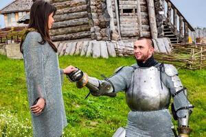 A knight in armor knelt before his lady heart. photo