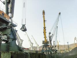 Cargo industrial port, port cranes. Loading of anthracite. Transportation of coal. Heap of coal photo