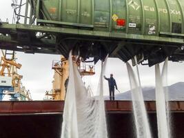 Russia, Novorossiysk 2021.  spillage of saltpeter from the car into the hold of the tanker. Loading of mineral fertilizers in the ship's hold. photo