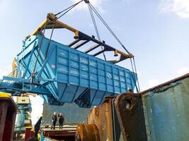 Russia, Novorossiysk 2021. Raising the hopper car for unloading on a cargo ship. Lifting operations in the port. photo