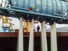 Russia, Novorossiysk 2021.  spillage of saltpeter from the car into the hold of the tanker. Loading of mineral fertilizers in the ship's hold. photo