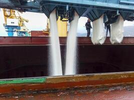 Russia, Novorossiysk 2021.  spillage of saltpeter from the car into the hold of the tanker. Loading of mineral fertilizers in the ship's hold. photo