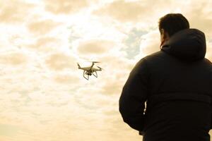 A man with a remote control in his hands. Controlling the flight photo