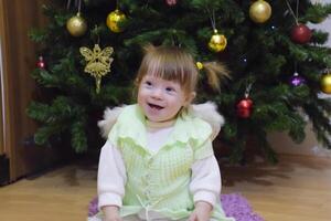 uno año antiguo bebé niña sentado en el antecedentes de el Navidad foto