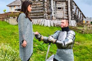 A knight in armor knelt before his lady heart. photo