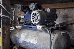 Air compressor with a receiver. Equipment under the workbench photo