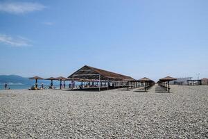 Beach canopies for protection from the sun on the seashore. Pebble beach Aleksino in Novorossiysk. photo