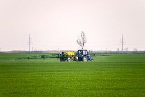 Tractor making fertilizer by spray photo