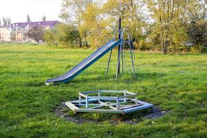 Children playground. Swings and a slide to slide photo