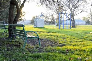 banco cerca el para niños patio de recreo cerca el estadio. niños patio de juegos. columpios y un diapositiva a diapositiva foto