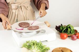 Grill Cooking Beef Burger Patty and Purple Onion on White Pan photo