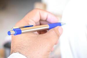 A man hold pen in Hand, metal pen photo