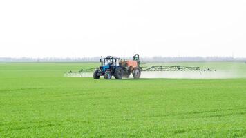 tractor con un rociar dispositivo para finamente disperso fertilizante. foto