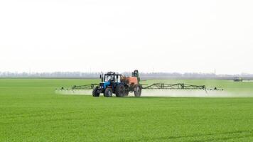 tractor con un rociar dispositivo para finamente disperso fertilizante. foto