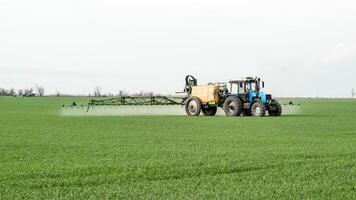 tractor con un rociar dispositivo para finamente disperso fertilizante. foto