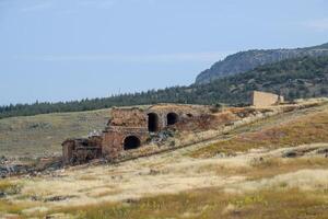 Ancient antique amphitheater in city of Hierapolis in Turkey. Side view. Steps and antique statues with columns in the amphitheater photo
