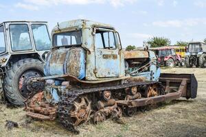 antiguo oxidado desmontado tractor. foto