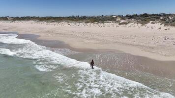 man walking in waves rockingham australia aerial 4k video